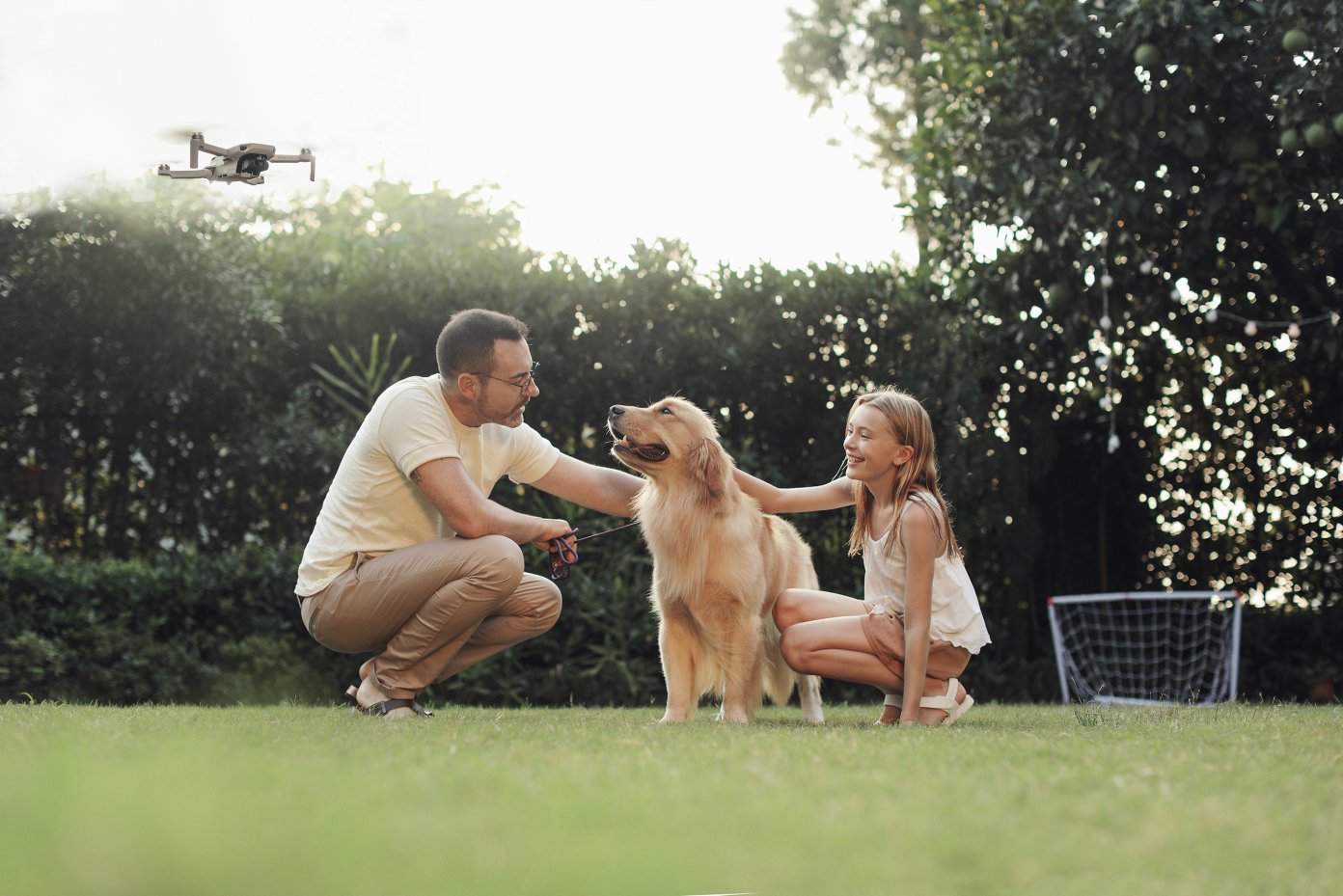 Family with dog and DJI Mavic Mini flying in background