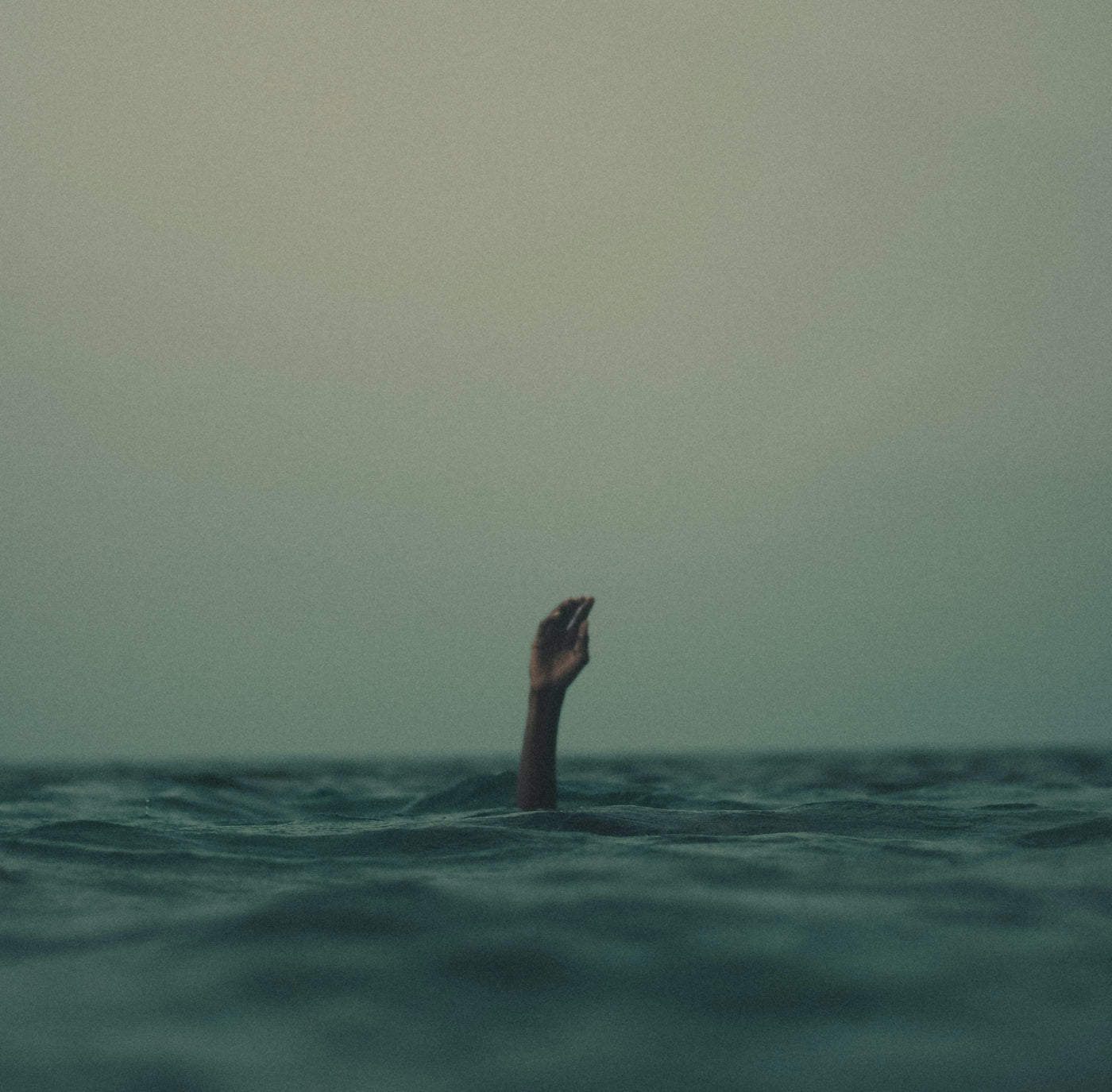 Hand in the ocean asking for help